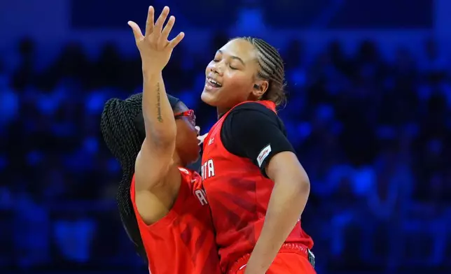 Atlanta Dream guard Allisha Gray, left, celebrates her three-pointer with forward Naz Hillmon during the second half of a WNBA basketball game against the Dallas Wings in Arlington, Texas, Tuesday, May 12, 2026. (AP Photo/LM Otero)