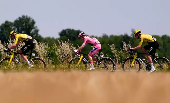 Pink jersey Denmark's Jonas Vingegaard, center, pedals during Stage 15 of the Giro d'Italia cycling race, from Voghera to Milan, Italy, Sunday, May 24, 2026. (Fabio Ferrari/LaPresse via AP)