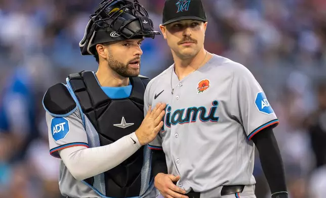 Miami Marlins catcher Joe Mack, left, gives starting pitcher Janson Junk, right, a congratulatory pat following fourth-inning baseball game action against the Toronto Blue Jays in Toronto, Monday May 25, 2026. (Frank Gunn/The Canadian Press via AP)