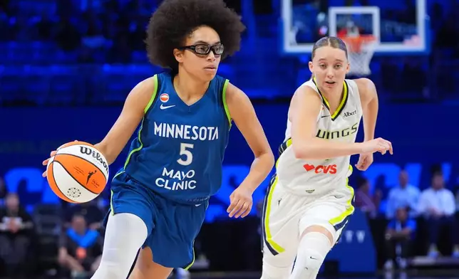 Minnesota Lynx guard Olivia Miles (5) drives past Dallas Wings guard Paige Bueckers during the second half of a WNBA basketball game in Arlington, Texas, Thursday, May 14, 2026. (AP Photo/LM Otero)