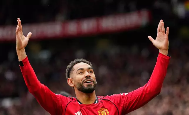 Manchester United's Matheus Cunha celebrates after scoring his side's opening goal during the English Premier League soccer match between Manchester United and Liverpool in Manchester, England, Sunday, May 3, 2026. (AP Photo/Dave Thompson)