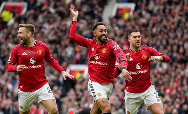 Manchester United's Matheus Cunha, centre, celebrates with teammates after scoring his side's opening goal during the English Premier League soccer match between Manchester United and Liverpool in Manchester, England, Sunday, May 3, 2026. (AP Photo/Dave Thompson)
