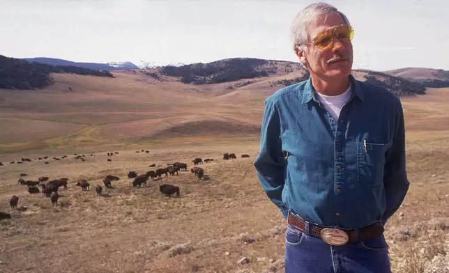 FILE - Ted Turner poses near a herd of his bison in September 1991 at his Flying D Ranch near Bozeman, Mont. (Linda Best/Bozeman Daily Chronicle via AP, File)