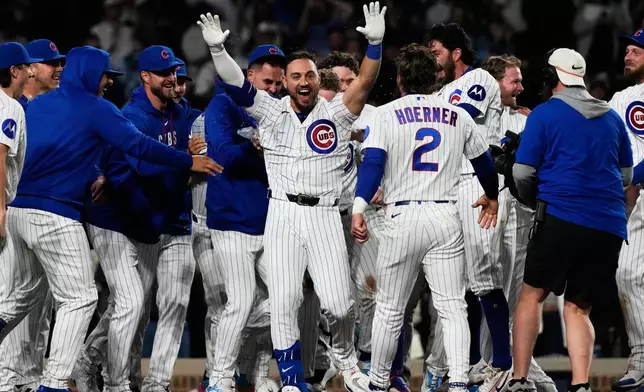 Chicago Cubs' Michael Conforto, center, celebrates with teammates after hitting the winning solo home run during the ninth inning of a baseball game against the Cincinnati Reds in Chicago, Monday, May 4, 2026. (AP Photo/Nam Y. Huh)
