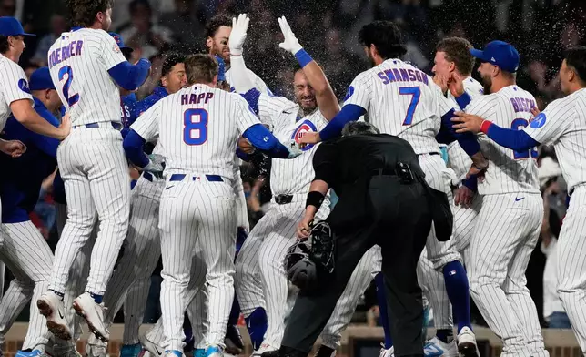 Chicago Cubs' Michael Conforto, center, celebrates with teammates after hitting the winning solo home run during the ninth inning of a baseball game against the Cincinnati Reds in Chicago, Monday, May 4, 2026. (AP Photo/Nam Y. Huh)