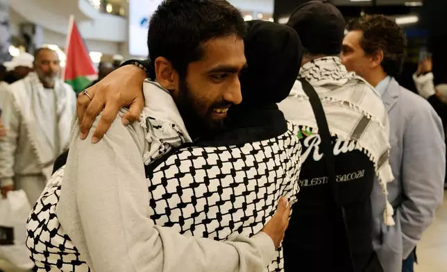 Yusuf Rahman, an activist embraces his family member after returning home at OR Tambo International Airport, in Johannesburg, South Africa, Saturday, May 23, 2026. (AP Photo/Themba Hadebe)