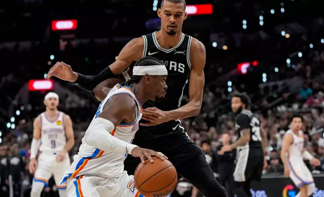 Oklahoma City Thunder guard Shai Gilgeous-Alexander (2) moves against San Antonio Spurs forward Victor Wembanyama (1) in the second half of Game 6 in the Western Conference finals NBA basketball playoffs series, Thursday, May 28, 2026, in San Antonio. (AP Photo/David J. Phillip)