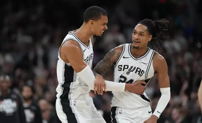 San Antonio Spurs forward Victor Wembanyama, left, and guard Devin Vassell react after a basket against the Oklahoma City Thunder during the second half of Game 4 in the Western Conference finals NBA basketball playoffs series in San Antonio, Sunday, May 24, 2026. (AP Photo/Eric Gay)