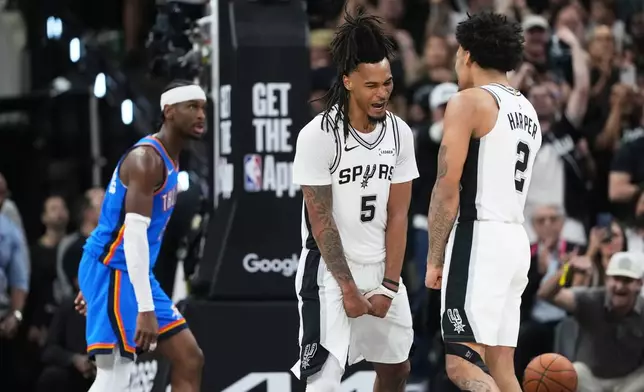 San Antonio Spurs guard Stephon Castle (5) and guard Dylan Harper, right, react after a basket as Oklahoma City Thunder guard Shai Gilgeous-Alexander, left, looks on during the second half of Game 4 in the Western Conference finals NBA basketball playoffs series in San Antonio, Sunday, May 24, 2026. (AP Photo/Eric Gay)