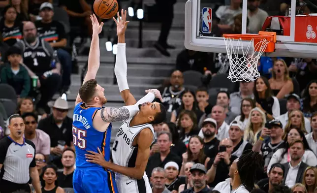 San Antonio Spurs forward Victor Wembanyama, right, blocks a shot by Oklahoma City Thunder center Isaiah Hartenstein during the second half of Game 4 in the Western Conference finals NBA basketball playoffs series in San Antonio, Sunday, May 24, 2026. (AP Photo/Darren Abate)