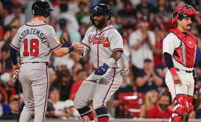 Atlanta Braves' Michael Harris II, center, is congratulated by Mike Yastrzemski (18) after his two-run home run, as Boston Red Sox's Mickey Gasper (30) waits for play to resume, during the eighth inning of a baseball game, Tuesday, May 26, 2026, in Boston. (AP Photo/Charles Krupa)
