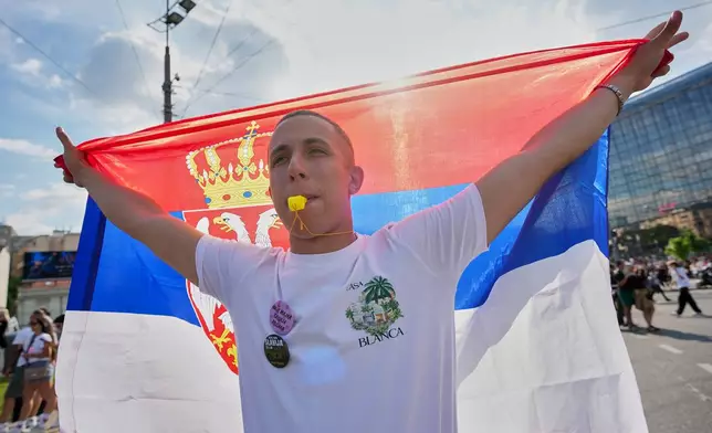 An anti-government protester blows a whistle before the first big rally of the year led by Serbia's protesting university students who are pushing for major political changes in the Balkan country run by President Aleksandar Vucic, in Belgrade, Serbia, Saturday, May. 23, 2026. (AP Photo/Darko Vojinovic)