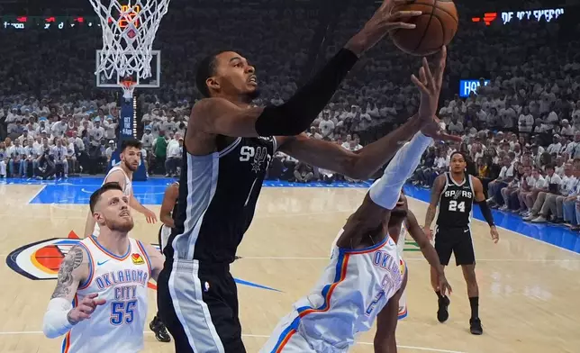 San Antonio Spurs forward Victor Wembanyama (1) and Oklahoma City Thunder guard Shai Gilgeous-Alexander (2) vie for a loose ball in the first half of Game 5 in the Western Conference finals NBA basketball playoffs series, Tuesday, May 26, 2026, in Oklahoma City. (AP Photo/Julio Cortez)