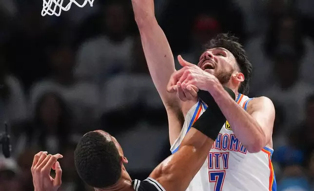 Oklahoma City Thunder center Chet Holmgren (7) makes a basket against San Antonio Spurs forward Victor Wembanyama (1) in the second half of Game 5 in the Western Conference finals NBA basketball playoffs series, Tuesday, May 26, 2026, in Oklahoma City. (AP Photo/Julio Cortez)