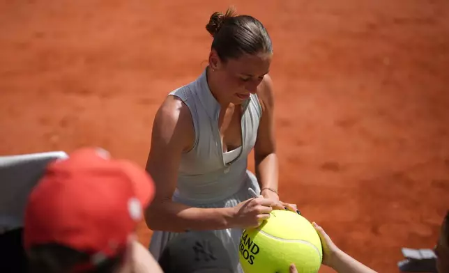 Marta Kostyuk of Ukraine signs autographs after winning against Oksana Selekhmeteva of Spain during their first round women's singles tennis match at the French Open tennis tournament in Paris, Sunday, May 24, 2026. (AP Photo/Thibault Camus)