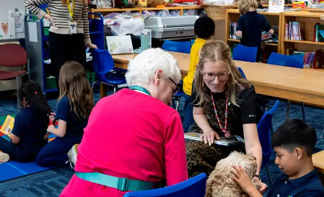 Ian, right, and school social worker Nicole Herje pet Sage, a therapy dog, at Valley View Elementary School on April 29, 2026, in Columbia Heights, Minn. (Ellen Schmidt/MinnPost via AP)