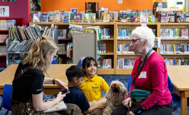 Yesli, center right, pets Sage, a therapy dog, at Valley View Elementary School on April 29, 2026, in Columbia Heights, Minn. (Ellen Schmidt/MinnPost via AP)