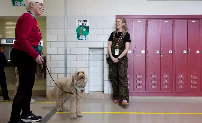 Linda Buchs-Hammonds, left, and her therapy dog, Sage, walk through the hallway at Valley View Elementary School with school social worker Nicole Herje, right, on April 29, 2026, in Columbia Heights, Minn. (Ellen Schmidt/MinnPost via AP)