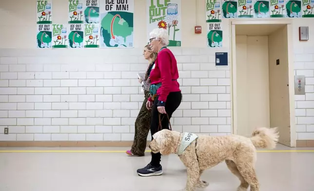 School social worker Nicole Herje walks through the hallway at Valley View Elementary School with Linda Buchs-Hammonds and her therapy dog Sage at Valley View Elementary School on April 29, 2026, in Columbia Heights, Minn. (Ellen Schmidt/MinnPost via AP)