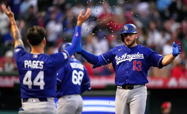 Los Angeles Dodgers' Max Muncy, right, has seeds thrown at him by Andy Pages after hitting a solo home run during the fourth inning of a baseball game against the Los Angeles Angels, Friday, May 15, 2026, in Anaheim, Calif. (AP Photo/Mark J. Terrill)