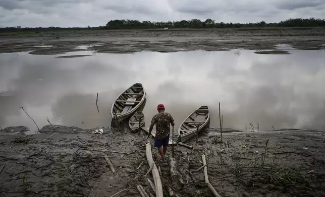 FILE - A fisherman walks to his boat in Santa Rosa, Peru, an island on the Amazon River, on Aug. 17, 2025. (AP Photo/Ivan Valencia, File)