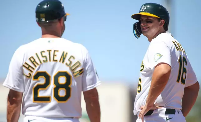 Athletics' Nick Kurtz, right, smiles at first base coach Ryan Christenson (28) after being intentionally walked during the seventh inning of a baseball game against the Kansas City Royals, Thursday, April 30, 2026, in West Sacramento, Calif. (AP Photo/Scott Marshall)