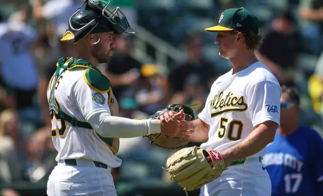 Athletics pitcher Jack Perkins (50) celebrates with catcher Austin Wynns, left, after the final out of the ninth inning of a baseball game as the Athletics defeat the Kansas City Royals Thursday, April 30, 2026, in West Sacramento, Calif. (AP Photo/Scott Marshall)