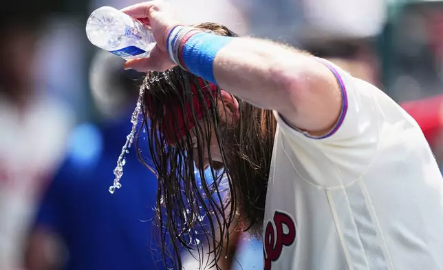 Philadelphia Phillies' Brandon Marsh pours water over his head to cool off during the fifth inning of a baseball game against the Cincinnati Reds, Wednesday, May 20, 2026, in Philadelphia. (AP Photo/Matt Rourke)