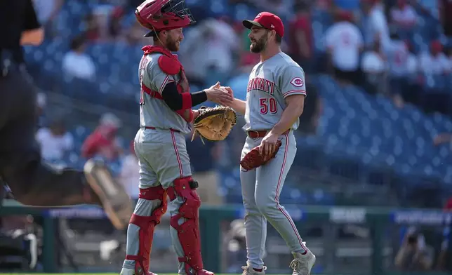 Cincinnati Reds catcher P.J. Higgins and pitcher Sam Moll celebrate their win after a baseball game against the Philadelphia Phillies, Wednesday, May 20, 2026, in Philadelphia. (AP Photo/Matt Rourke)