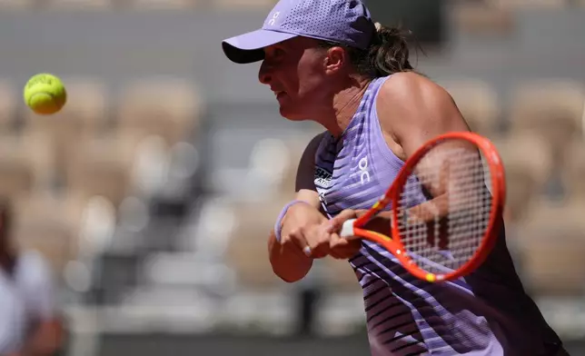 Iga Swiatek of Poland returns to Sara Bejlek of the Czech Republic during their second round women's singles tennis match at the French Open tennis tournament in Paris, Wednesday, May 27, 2026. (AP Photo/Thibault Camus)