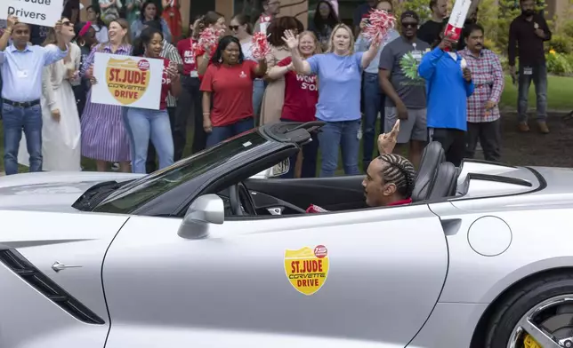 A Corvette driver arrives at St. Jude as supporters cheer during the 15th annual St. Jude Corvette Drive in Memphis. Courtesy of ALSAC/St. Jude Children’s Research Hospital.