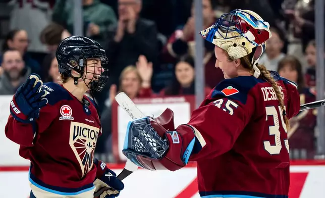 Montreal Victoire's Marie-Philip Poulin (29) celebrates with goaltender Ann-Renee Desbiens (35) after defeating the Minnesota Frost in PWHL playoff hockey action in Laval, Que., on Tuesday, May 12, 2026. (Christopher Katsarov/The Canadian Press via AP)