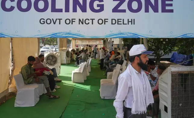 Commuters rest at a roadside cooling station set up by the government to provide relief for people from the intense summer heat in New Delhi, India, Wednesday, May 20, 2026. (AP Photo/Manish Swarup)
