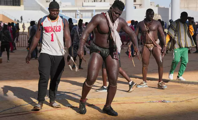 A wrestler performs a traditional dance at a wrestling competition at the national arena in Dakar, Senegal, Sunday, March 29, 2026. (AP Photo/Misper Apawu)