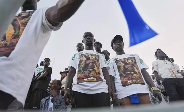 Fans of wrestler Modou Lo look on after his defeat at the national wrestling arena in Dakar, Senegal, Sunday, April 5, 2026. (AP Photo/Misper Apawu)