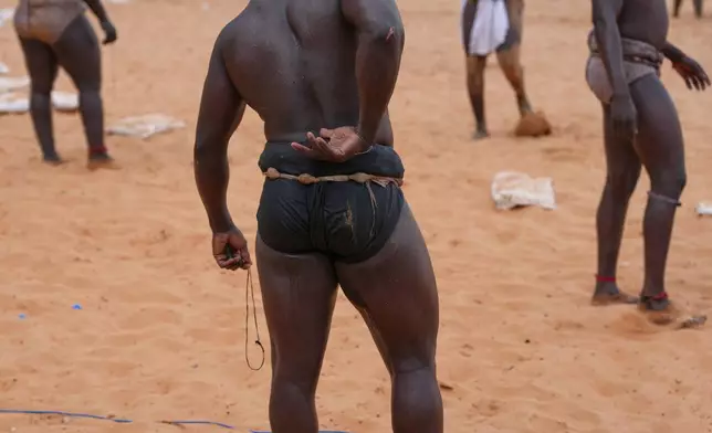 Wrestlers wait to compete at the national wrestling arena in Dakar, Senegal, Sunday, March 29, 2026. (AP Photo/Misper Apawu)