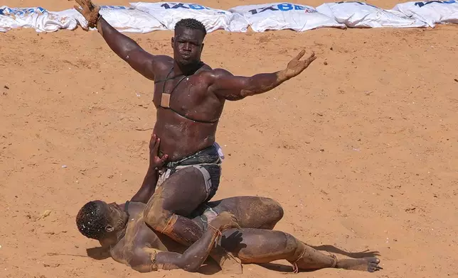Wrestlers compete at the national wrestling arena in Dakar, Senegal, Sunday, April 5, 2026. (AP Photo/Misper Apawu)
