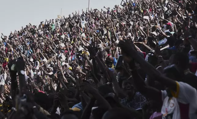 Fans cheer at a wrestling competition at the National Arena in Dakar, Senegal, Sunday, April 5, 2026. (AP Photo/Misper Apawu)
