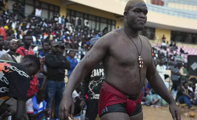 A wrestler waits to compete at the national wrestling arena in Dakar, Senegal, Sunday, March 29, 2026. (AP Photo/Misper Apawu)