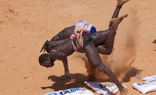 Wrestlers compete at the national wrestling arena in Dakar, Senegal, Sunday, April 5, 2026. (AP Photo/Misper Apawu)