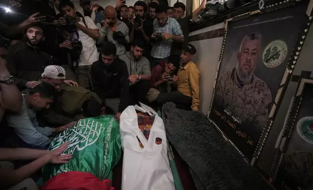 Palestinians mourn over the bodies of Izz al-Din al-Haddad, the leader of Hamas' Qassam Brigades, left, his daughter, center and wife during their funeral in Gaza City, Saturday, May 16, 2026. (AP Photo/Jehad Alshrafi)