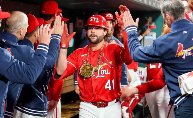 St. Louis Cardinals' Alec Burleson is congratulated by teammates after hitting a solo home run during the third inning against the Los Angeles Dodgers Friday, May 1, 2026, in St. Louis. (AP Photo/Scott Kane)