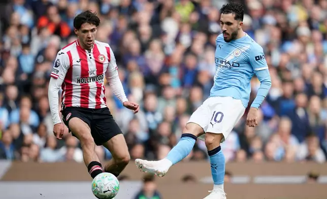 Brentford's Aaron Hickey, left, tries to block a shot from Manchester City's Rayan Cherki during the English Premier League soccer match between Manchester City and Brentford in Manchester, Saturday, May 9, 2026. (AP Photo/Dave Thompson)