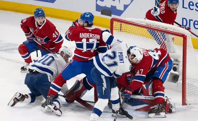 Tampa Bay Lightning's Brayden Point (21) battles for a rebound with teammate Corey Perry (10) and Montreal Canadiens' Jayden Struble (47), Josh Anderson (17), Lane Hutson (48) and goaltender Jakub Dobes (75) during the first period of Game 6 in the first round of an NHL hockey Stanley Cup playoff series in Montreal on Friday, May 1, 2026. (Christinne Muschi/The Canadian Press via AP)