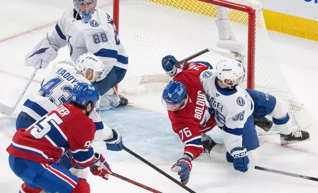 Montreal Canadiens' Alexandre Texier (85) reaches for a rebound with Tampa Bay Lightning's Darren Raddysh (43) as Canadiens' Zachary Bolduc (76) and Lightning's Brandon Hagel (38) battle in front of the Lightning net during the second period of Game 6 in the first round of an NHL hockey Stanley Cup playoff series in Montreal, Friday, May 1, 2026. (Christinne Muschi/The Canadian Press via AP)
