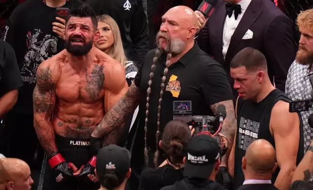 Mike Perry, of the United States, left, celebrates after defeating Nate Diaz, of the United States, right, in their welterweight mixed martial arts fight Saturday, May 16, 2026, in Inglewood, Calif. (AP Photo/Jae C. Hong )