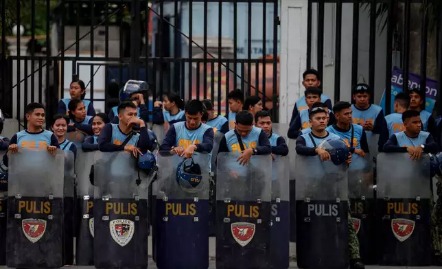 Police personnel stand behind their shields outside the Senate of the Philippines, in Manila, Thursday May 14, 2026. (AP Photo/Gerard Carreon)