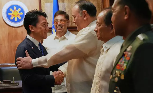 Philippine Defense Secretary Gilbert Teodoro Jr. greets his counterpart Japan's Shinjiro Koizumi, left, at the Malacanang presidential palace in Manila, Philippines on Tuesday, May 5, 2026. (AP Photo/Aaron Favila, Pool)