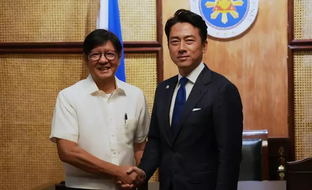 Philippine President Ferdinand Marcos Jr., left, greets Japan's Defense Minister Shinjiro Koizumi at the Malacanang presidential palace in Manila, Philippines on Tuesday, May 5, 2026. (AP Photo/Aaron Favila, Pool)