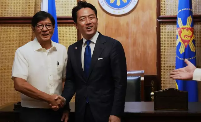 Philippine President Ferdinand Marcos Jr., left, greets Japan's Defense Minister Shinjiro Koizumi at the Malacanang presidential palace in Manila, Philippines on Tuesday, May 5, 2026. (AP Photo/Aaron Favila, Pool)